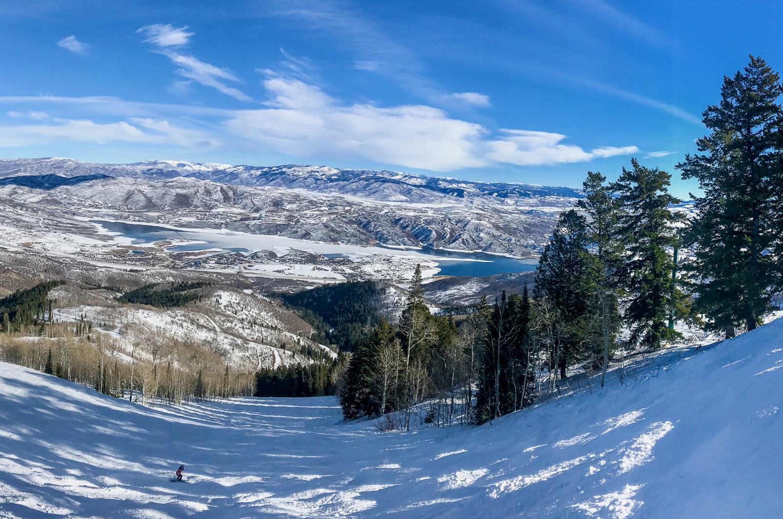 Skier descending new Deer Valley East Village terrain overlooking Jordanelle Reservoir