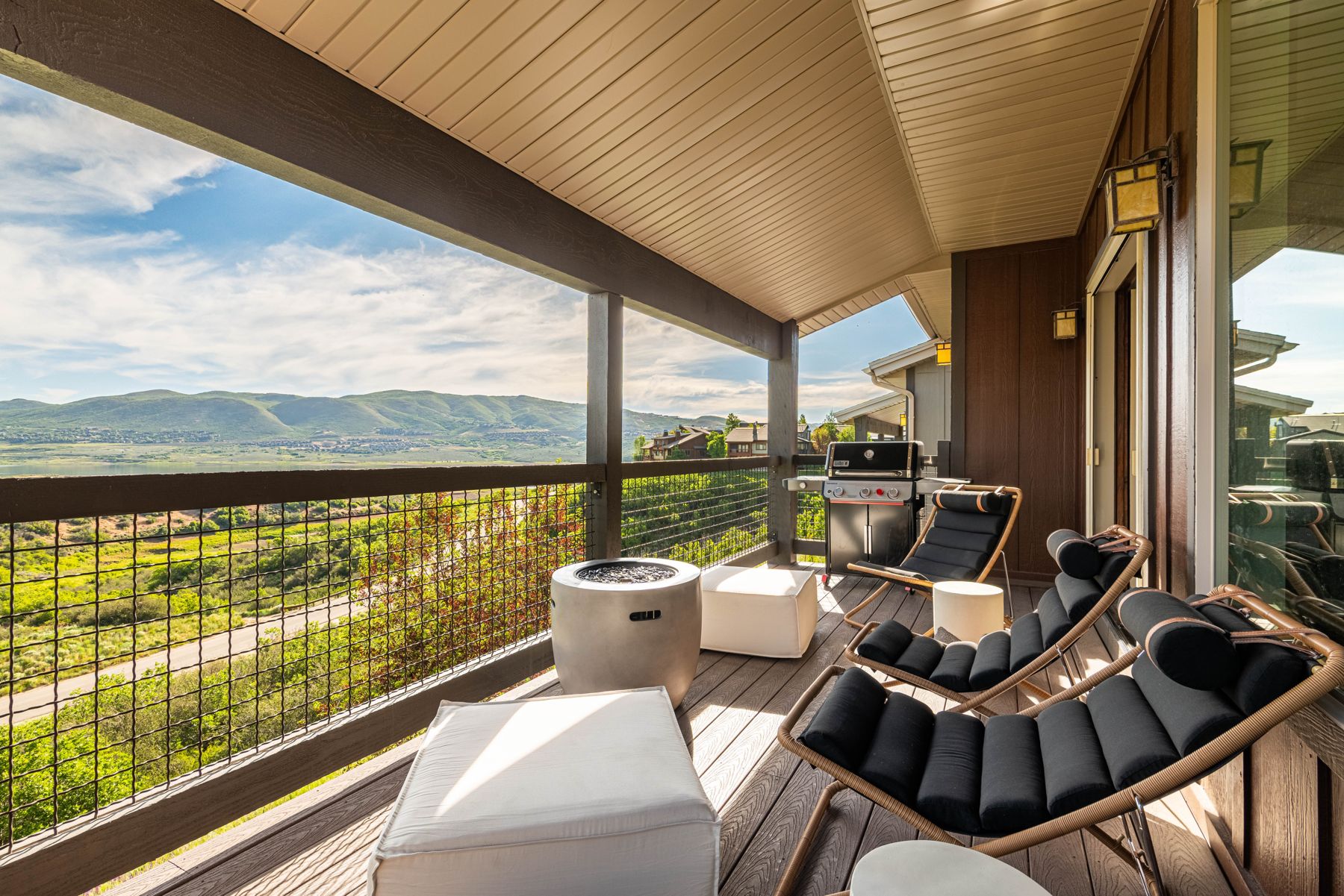Covered deck lounge seating with panoramic Jordanelle Reservoir and mountain views at Mayflower Vista
