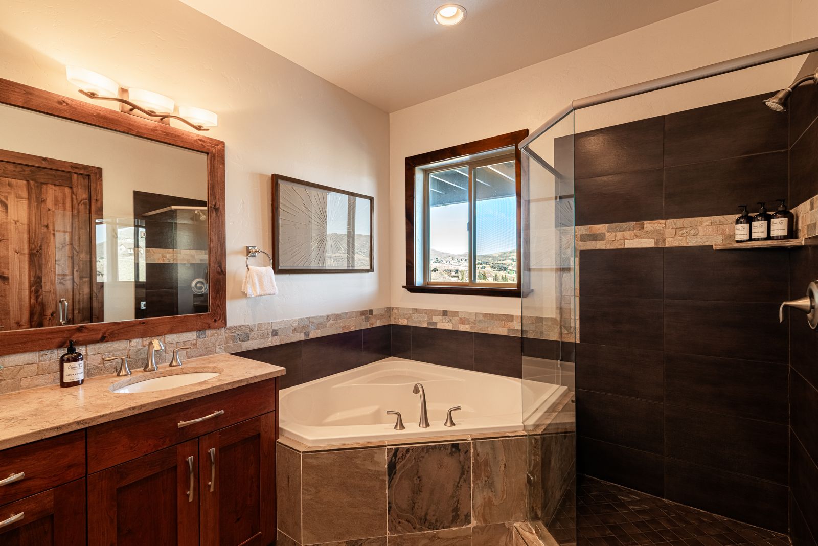 Primary ensuite master bathroom with dual vanity, deep soaking tub, and glass walk-in shower