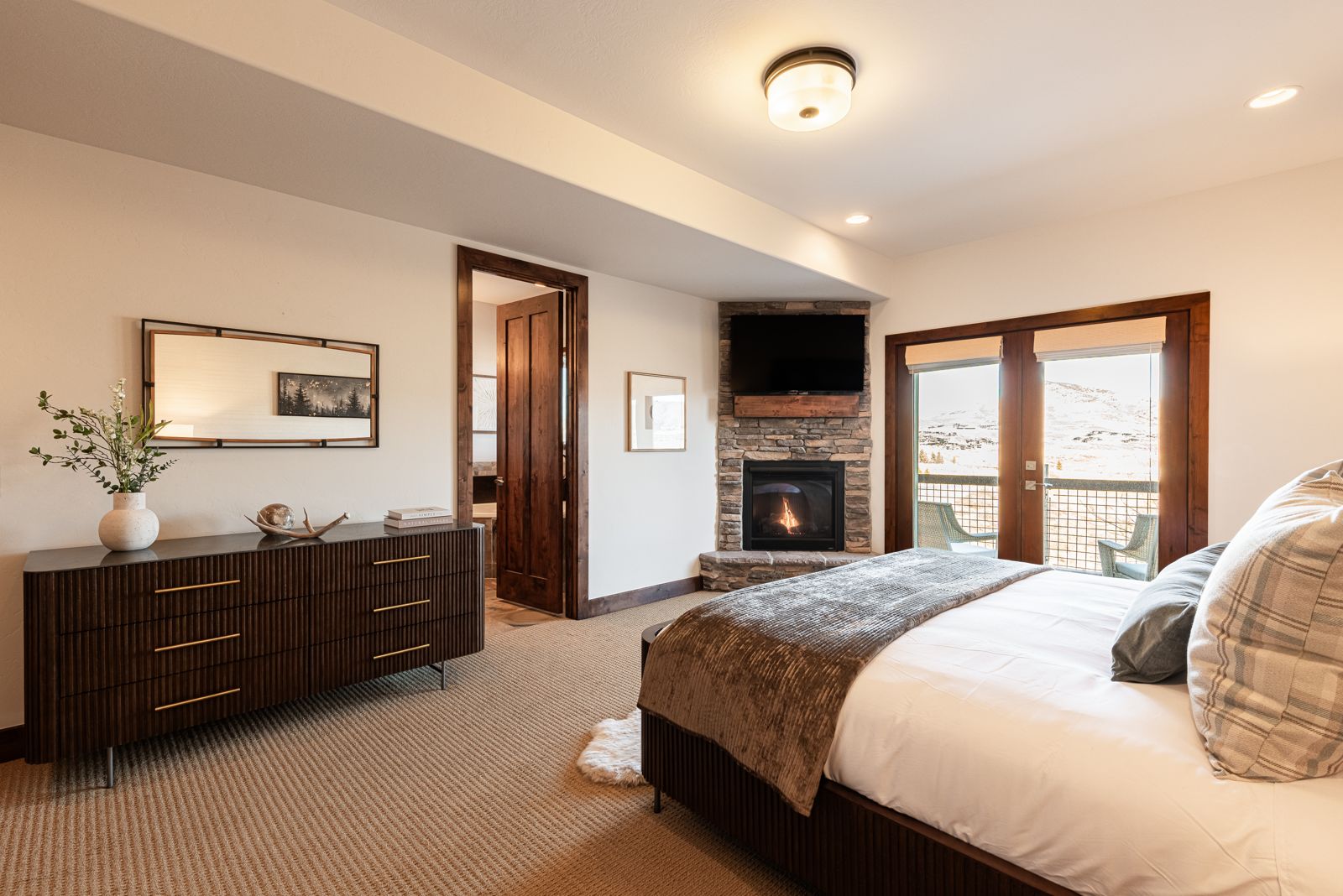 Primary king master bedroom suite with gas fireplace and private deck overlooking Jordanelle
